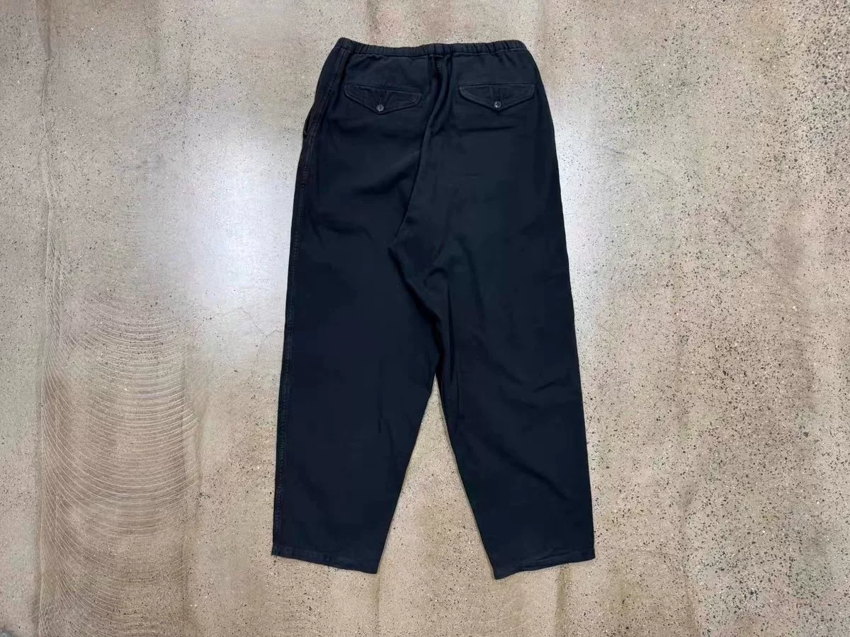 COMOLI Cotton Duck Tapered Pants — label