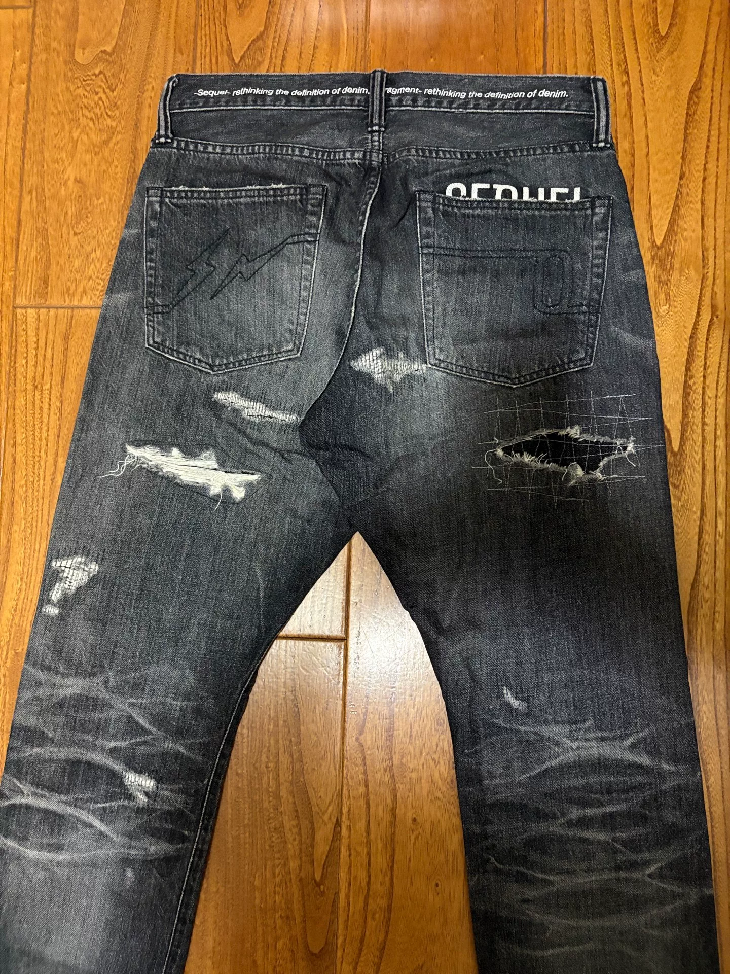 Sequel Fragment Distressed Washed Denim Pants — label