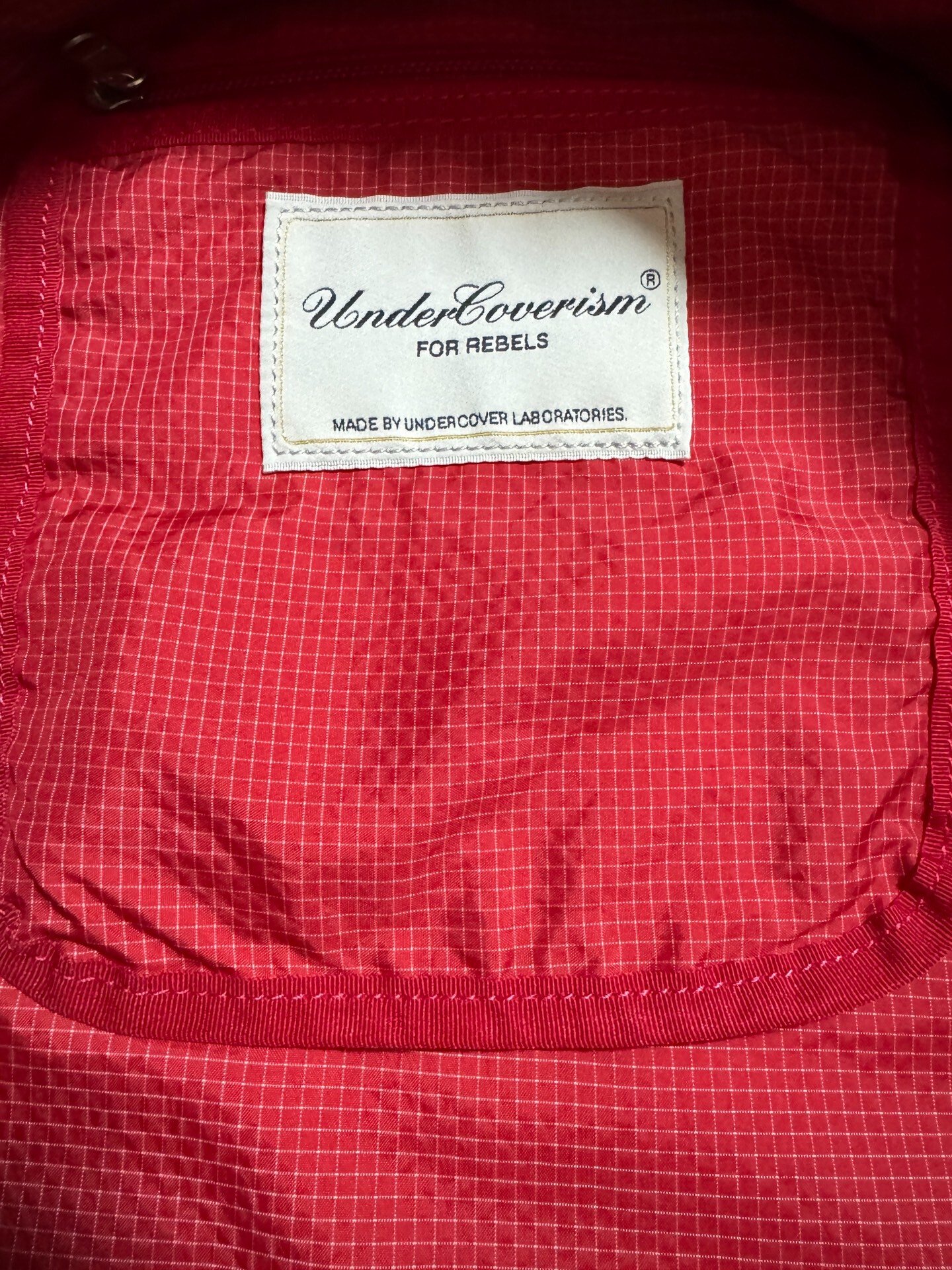 Undercover Multi-Pocket Embroidered Backpack — label